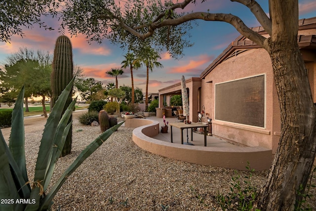 yard at dusk featuring a patio