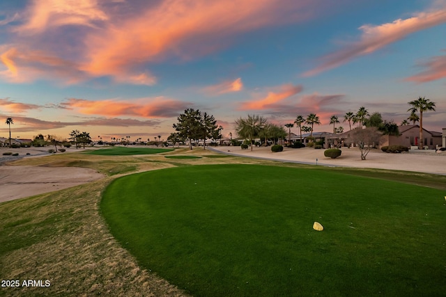 surrounding community featuring golf course view and a lawn