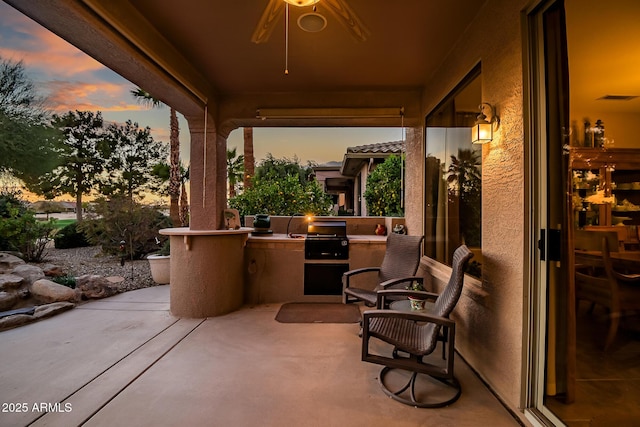 view of patio / terrace featuring visible vents, an outdoor kitchen, a grill, and a ceiling fan