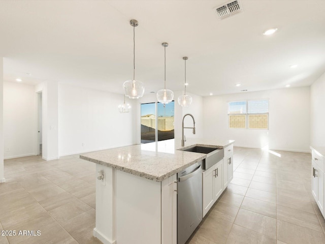 kitchen with sink, white cabinets, stainless steel dishwasher, and an island with sink