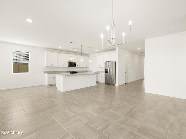 kitchen featuring white cabinetry, hanging light fixtures, an island with sink, stainless steel appliances, and a chandelier