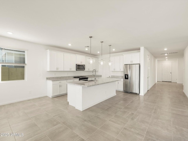 kitchen with decorative light fixtures, light stone countertops, an island with sink, stainless steel appliances, and white cabinets