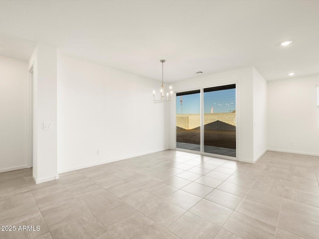 spare room with a notable chandelier and light tile patterned flooring