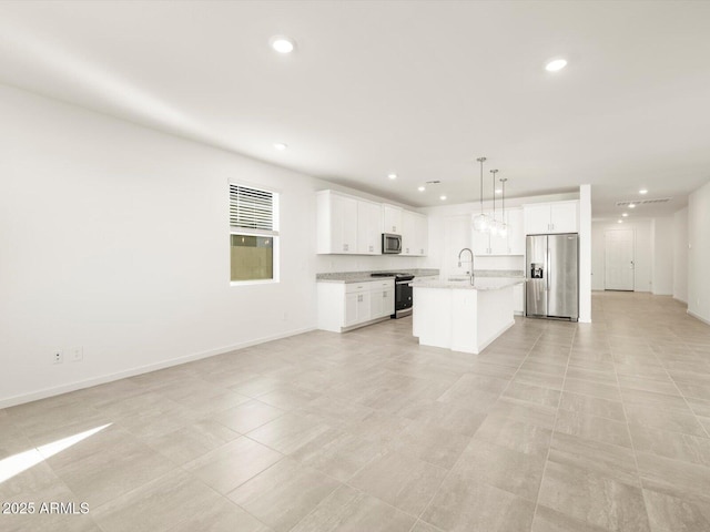 kitchen featuring sink, white cabinetry, hanging light fixtures, an island with sink, and stainless steel appliances