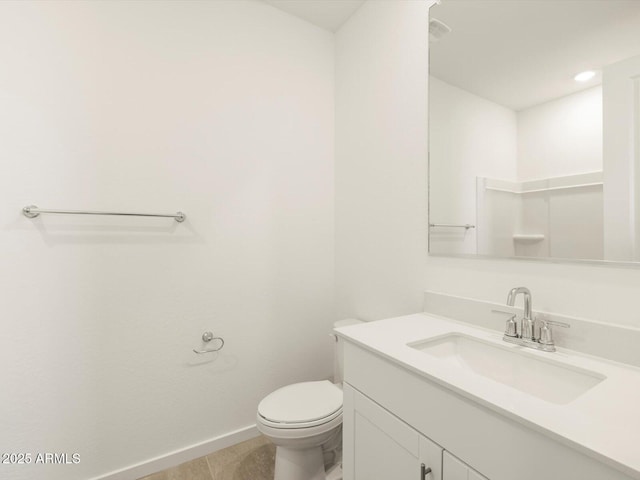 bathroom with toilet, vanity, and tile patterned flooring