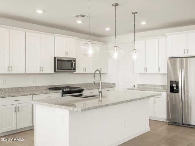 kitchen with a center island with sink, appliances with stainless steel finishes, and white cabinets