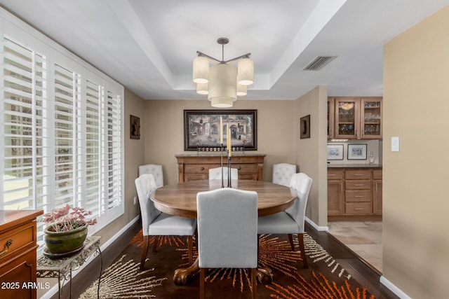 410 E Beck Ln, Phoenix, AZ 85022 - dining space featuring a tray ceiling, light wood-type flooring, healthy amount of natural light, and baseboards
