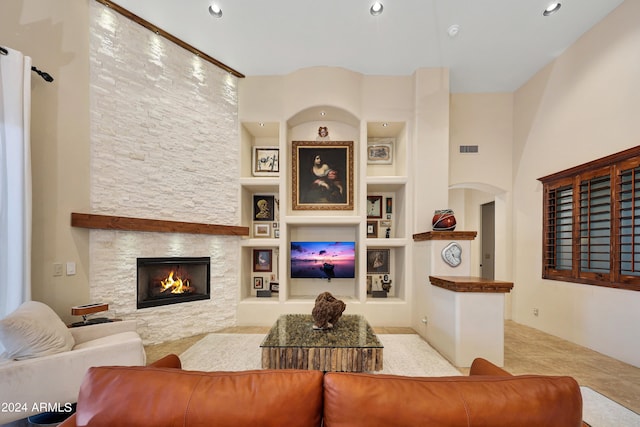 living room with light tile patterned floors, a fireplace, and built in shelves