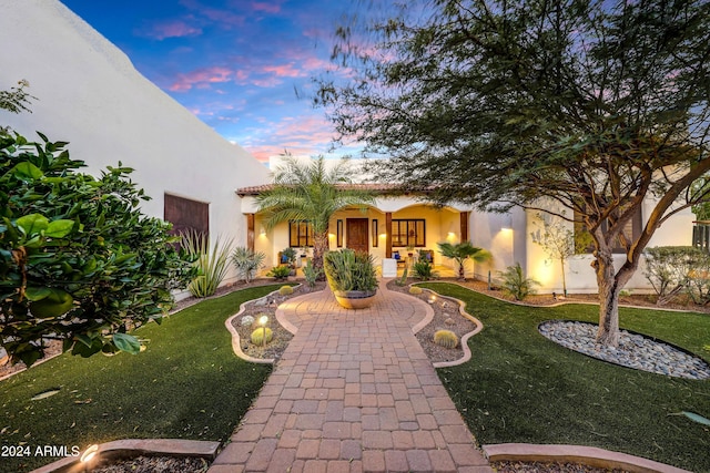 mediterranean / spanish house featuring a lawn