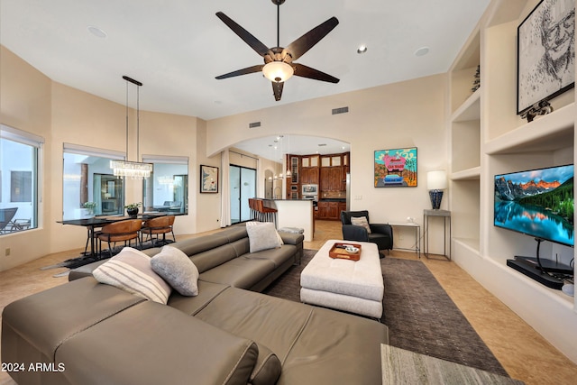 28217 N 139th St, Scottsdale, AZ 85262 - living room featuring arched walkways, built in shelves, a ceiling fan, a chandelier, and recessed lighting