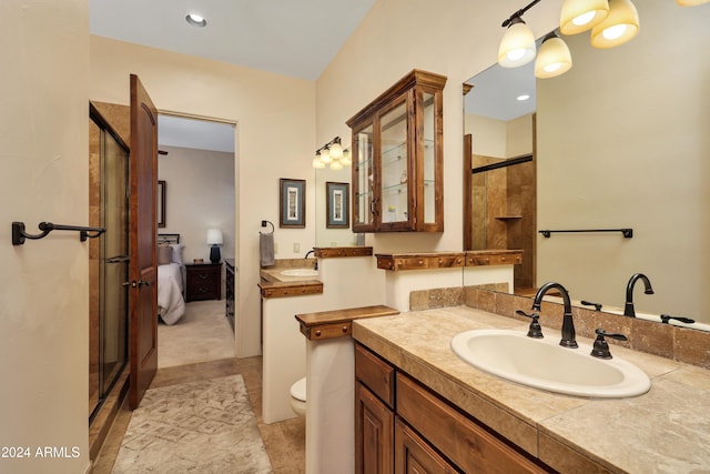 bathroom featuring vanity, a shower with shower door, toilet, and tile patterned flooring