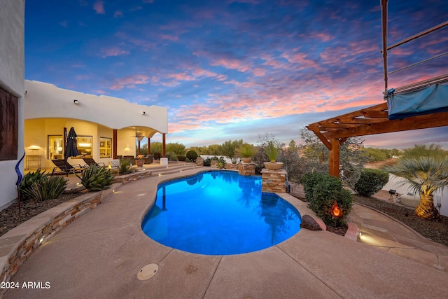 pool at dusk featuring a patio and a pergola