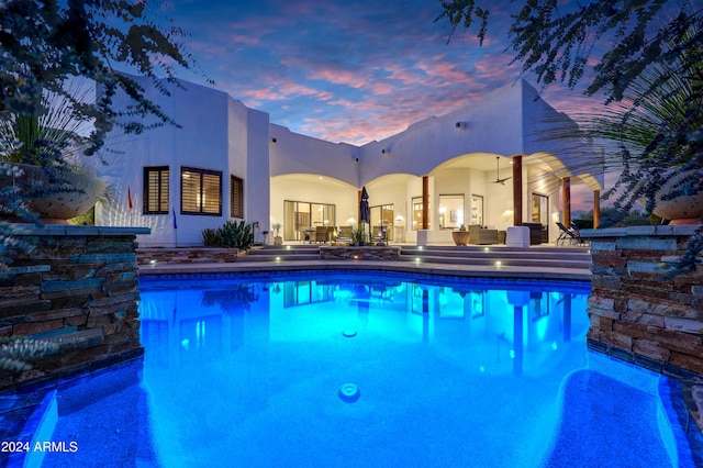 pool at dusk with a patio area