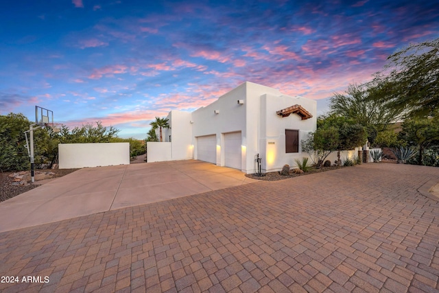 property exterior at dusk featuring a garage