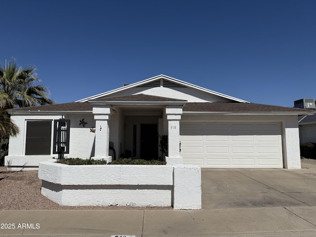 view of front of property featuring a shingled roof, central air condition unit, stucco siding, a garage, and driveway