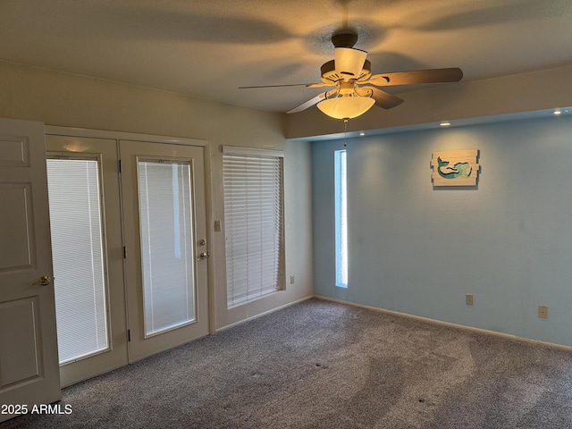 empty room with a ceiling fan, baseboards, and carpet floors