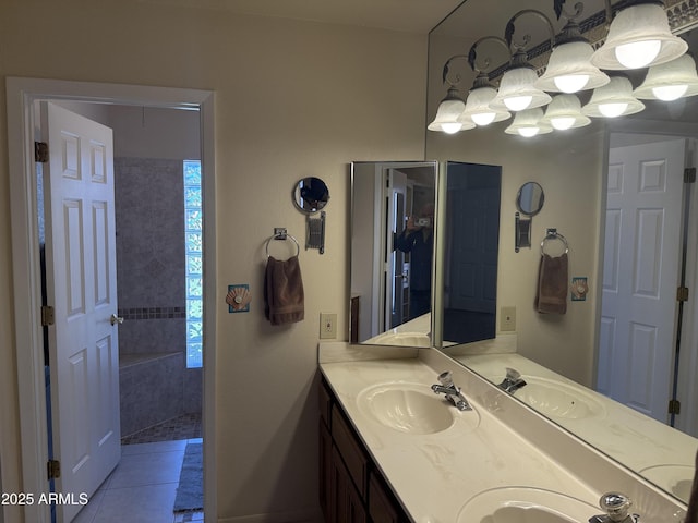 bathroom featuring tile patterned floors, tiled shower, double vanity, and a sink