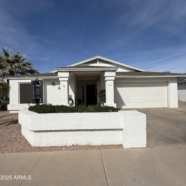 view of front of property featuring a garage, driveway, and stucco siding