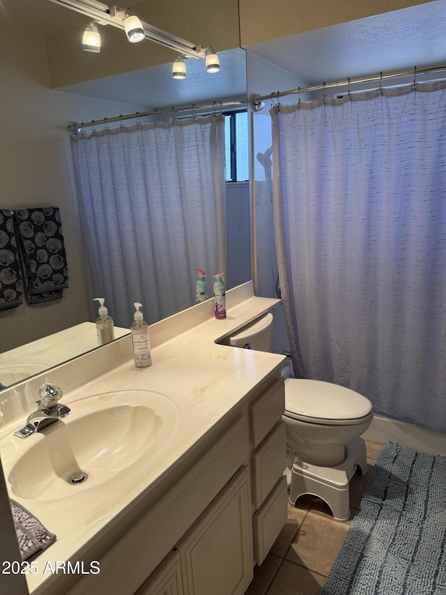 bathroom with tile patterned flooring, curtained shower, toilet, and vanity