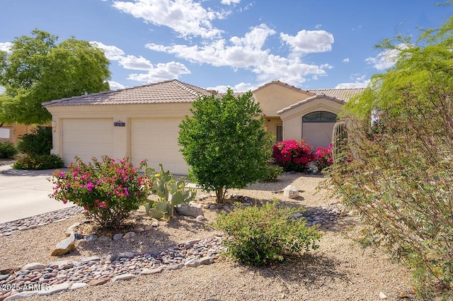 view of front of property with a garage, a tiled roof, and stucco siding