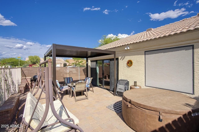 view of patio / terrace with outdoor dining area, a fenced backyard, and a hot tub