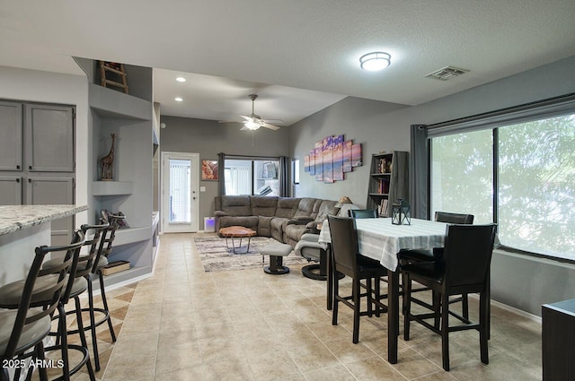 dining area with baseboards, plenty of natural light, a ceiling fan, and visible vents