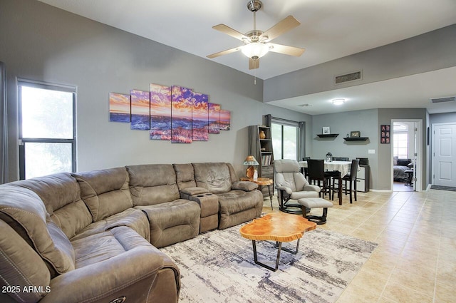 living area with light tile patterned floors, a ceiling fan, and visible vents