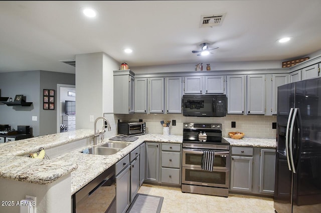 kitchen with a sink, visible vents, a peninsula, gray cabinetry, and black appliances