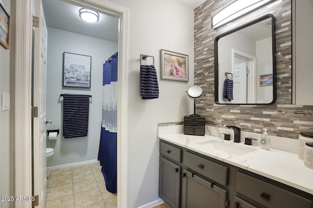 full bathroom with tile patterned flooring, vanity, toilet, baseboards, and decorative backsplash