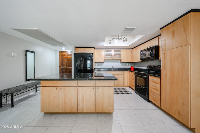 kitchen featuring visible vents, light brown cabinetry, light tile patterned flooring, black appliances, and a sink