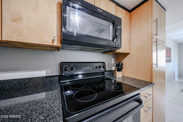 kitchen with light brown cabinetry, tile patterned floors, black appliances, and baseboards