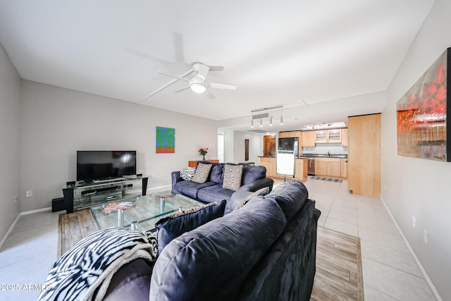 living room featuring light tile patterned floors, baseboards, ceiling fan, and track lighting