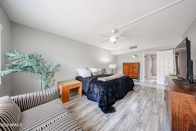 bedroom with visible vents, light wood-style flooring, and a ceiling fan