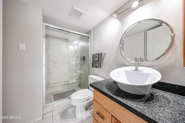 full bath featuring vanity, visible vents, a stall shower, tile patterned floors, and toilet