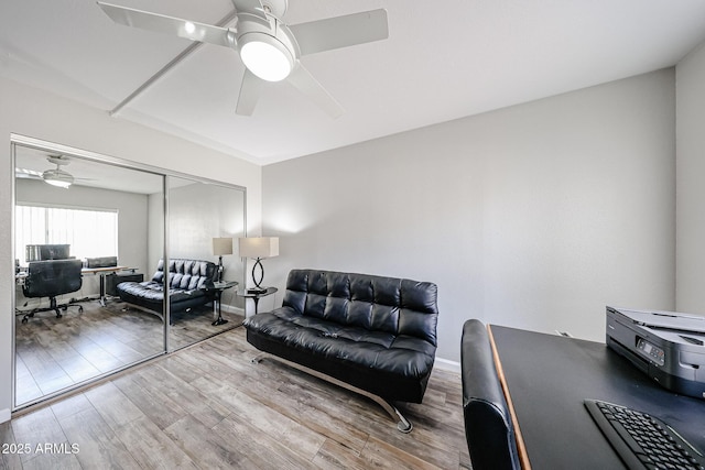 interior space with ceiling fan, baseboards, and wood finished floors