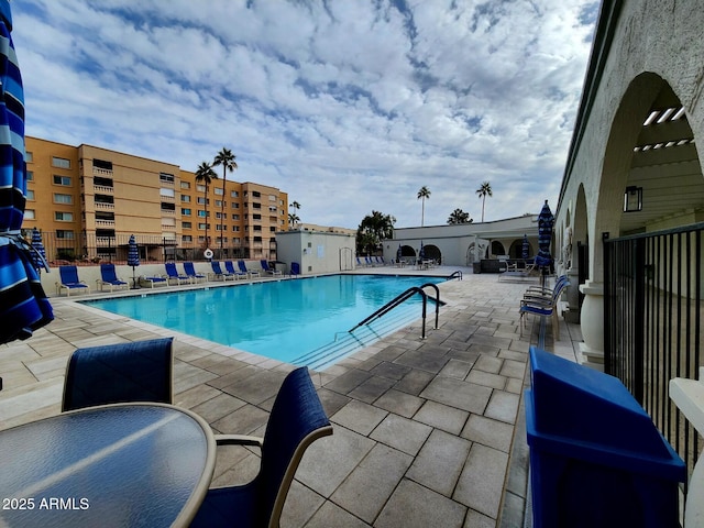 community pool featuring a patio and fence