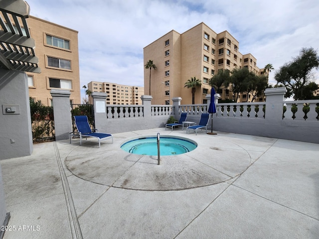 view of pool with a community hot tub and fence