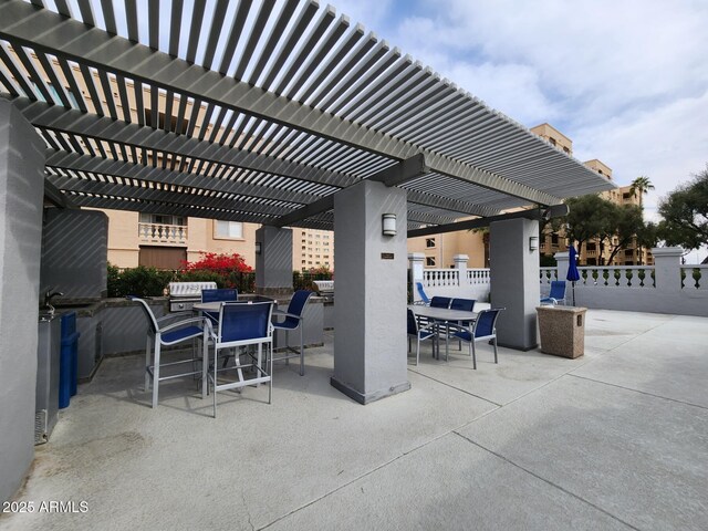 view of patio / terrace with outdoor dining space, a sink, and fence