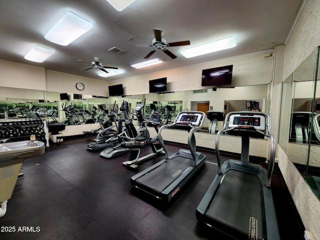 gym with visible vents, ceiling fan, and a textured wall