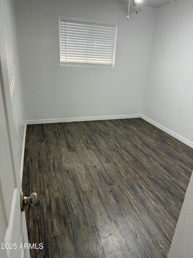 unfurnished room with dark wood-type flooring