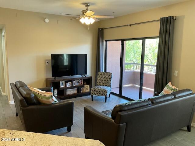 living room featuring ceiling fan and light hardwood / wood-style flooring