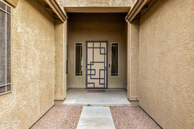view of exterior entry featuring stucco siding