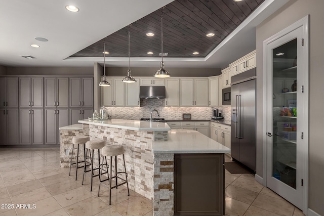 17673 E Bronco Dr, Queen Creek, AZ 85142 - kitchen featuring built in appliances, decorative backsplash, under cabinet range hood, and a raised ceiling