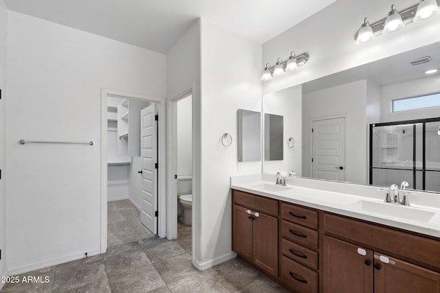 5429 W Chuck Box Rd, Laveen, AZ 85339 - full bathroom with baseboards, toilet, double vanity, a stall shower, and a spacious closet