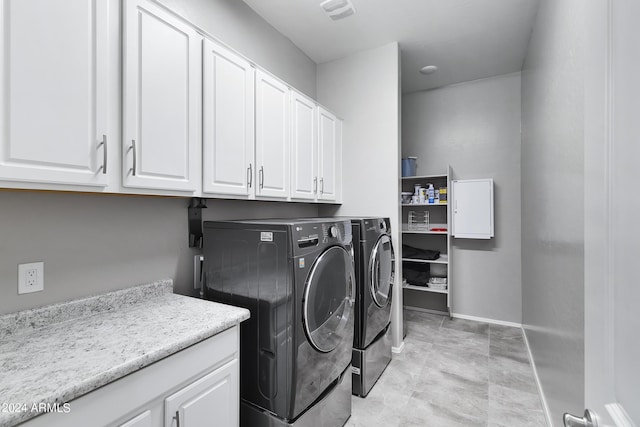 laundry area featuring baseboards, independent washer and dryer, cabinet space, and visible vents