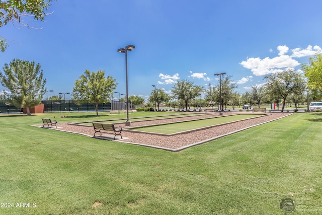 view of home's community featuring a lawn and fence