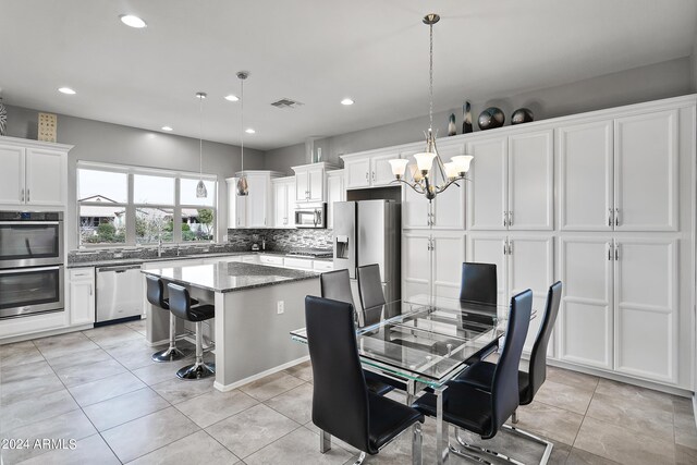 tiled dining room featuring an inviting chandelier