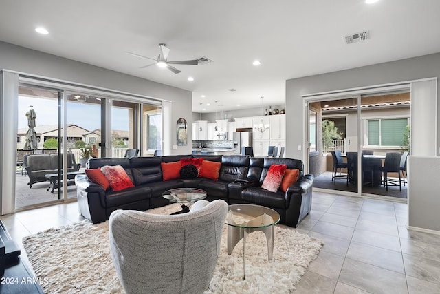 living area with light tile patterned floors, ceiling fan with notable chandelier, recessed lighting, and visible vents