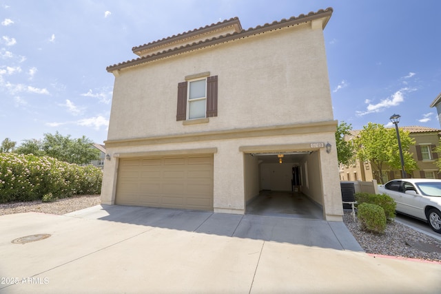 5749 S 21st Ter, Phoenix, AZ 85040 - view of side of home with a garage, stucco siding, and concrete driveway