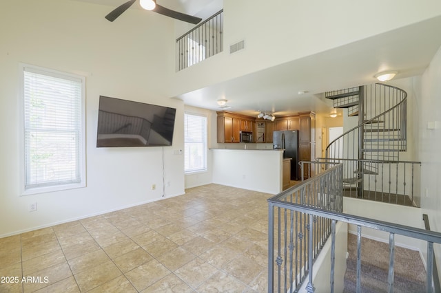 5749 S 21st Ter, Phoenix, AZ 85040 - unfurnished living room featuring ceiling fan, baseboards, and a towering ceiling
